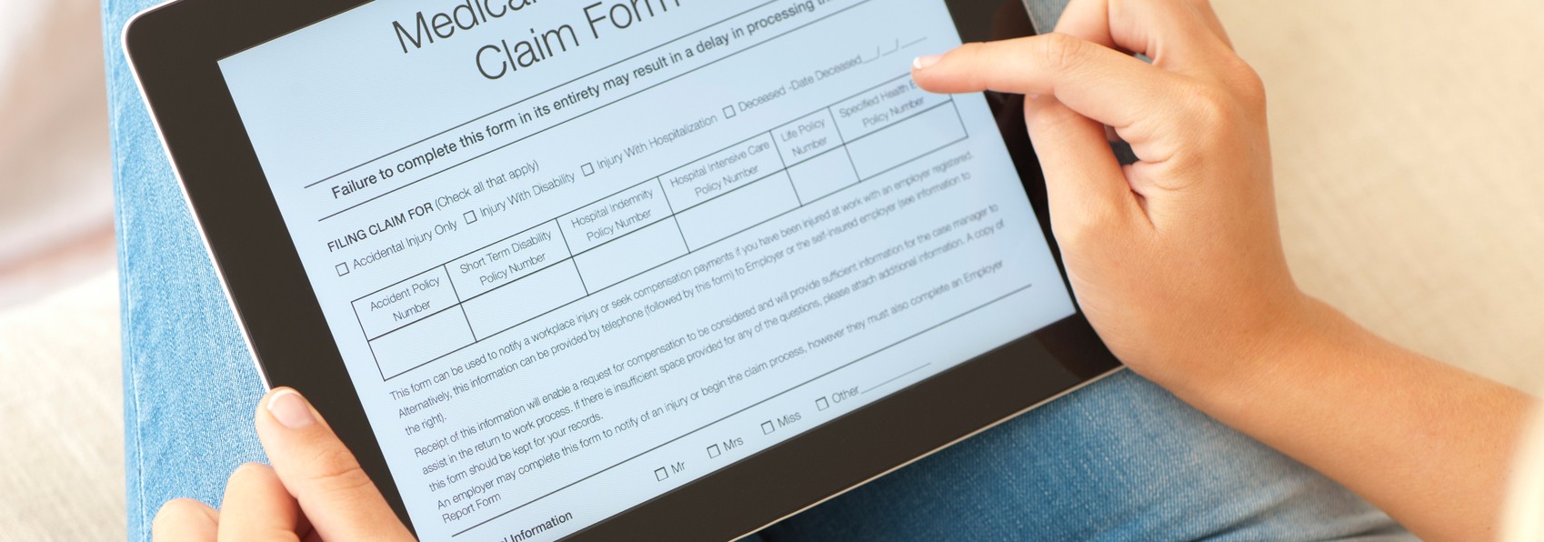 a woman reading medical claim form on table device